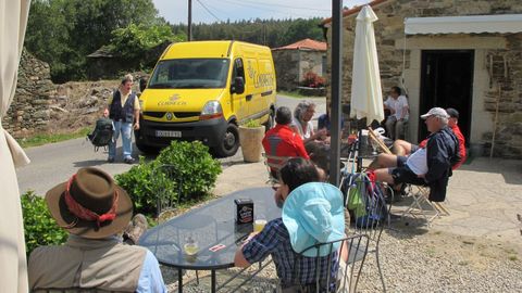 Un repartidor de Correos entrega mochilas en un albergue de Palas de Rei.