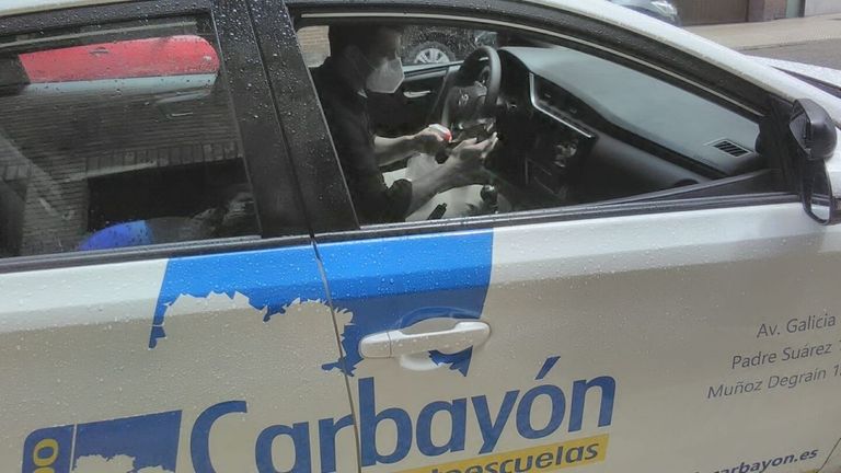 Jesús Lozano, de la autoescuela Carbayón, limpia su coche tras una clase