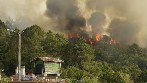 Vecinos de O Ribeiro observan las llamas de uno de los focos iniciados esta semana en su comarca