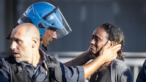 Un polica consuela a una mujer mientras un centenar de inmigrantes protestan en la plaza de la Independencia en Roma
