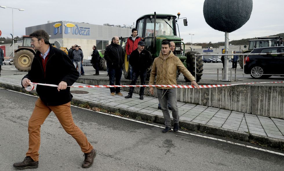 Santalla y Lamazares, colocando la cinta para impedir el acceso a la zona comercial lalinense. 