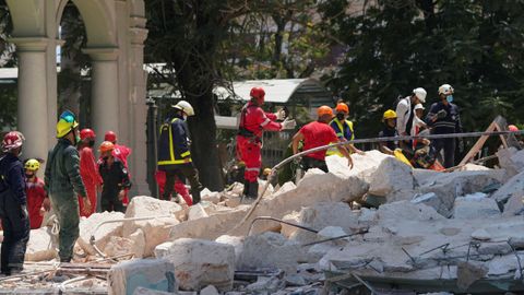 Rescatistas y bomberos trabajan en el lugar luego de que una explosión destruyera el Hotel Saratoga.