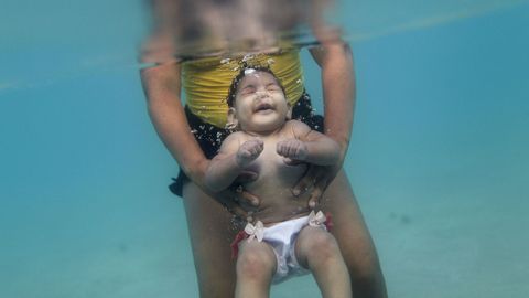 Rosana Vieira y su hija Luana, que nació con una microencefalia a causa de la picadura del Zika, posan para los fotógrados en una playa de Brasil. 