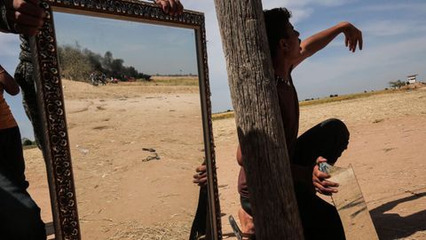 Un palestino utiliza espejos para despistar a los miembros del Ejrcito israel, en Khan Yunis