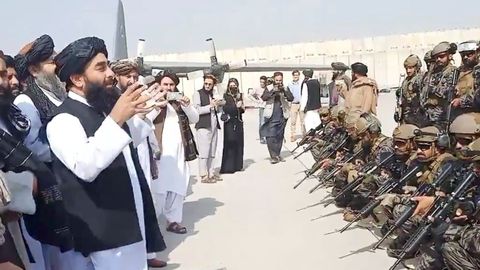 Miembros de la unidad militar montando guardia mientras el portavoz talibán pronuncia su discurso