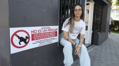 Lola Muoz, junto al cartel que ha colocado en la fachada de su negocio. 