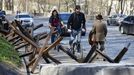 Dos hombres circulan en bicicleta junto a vallas antitanques amontonadas en la cuneta de una calle de Kiev