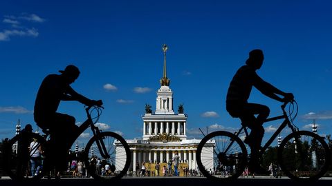 Hombres andan en bicicleta por un callejn del Centro de Exposiciones de Rusia (VDNKh), una feria comercial y parque de atracciones, en Mosc