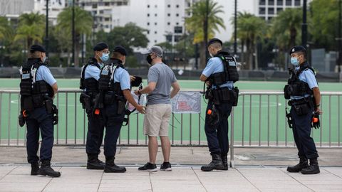 Agentes de la Polica de Hong Kong interroga a un viandante que fotografiaba zonas del parque Victoria.