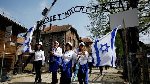 Gente ondea banderas israeles en el campo de concentracin de Auschwitz