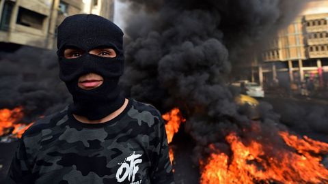 Un manifestante participa en la quema de neumticos durante una protesta en la plaza Wathba de Bagdad