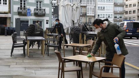 Los camareros preparan las mesas en un bar de Santiago