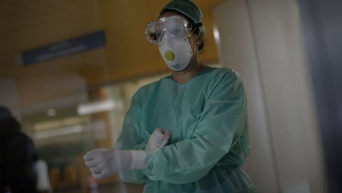 Enfermera del Chuac colocndose el equipo de proteccin durante la pandemia del coronavirus