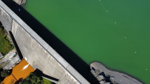 En esta foto aérea se ve que el agua que sale por la base de la presa tiene una fuerte coloración rojiza, mientras que la del embalse presenta un intenso tono verde
