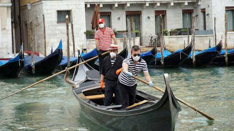 Gondoleros con mascarilla en Venecia