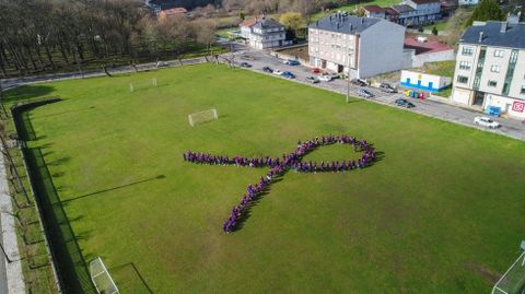 Estudiantes del colegio de Escairón forman un lazo morado en un campo de fútbol para conmemorar así el 8 de Marzo