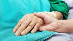 Una persona toma la mano de un enfermo, en una imagen de archivo
