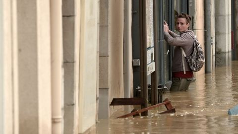 Una joven se agarra a unos barrotes durante una riada en el sur de Francia