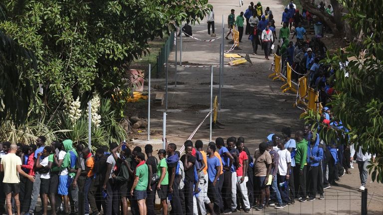 Varias decenas de inmigrantes hacen cola en el interior centro de acogida de Las Raíces, en La Laguna (Tenerife), donde han sido alojados buena parte de las personas que han llegado en los últimos días en cayuco a El Hierro y Tenerife