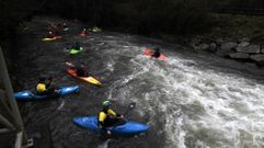 Jóvenes aficionados al piragüismo aprovechan una crecida para entrenarse en el río Cabe cerca de Monforte