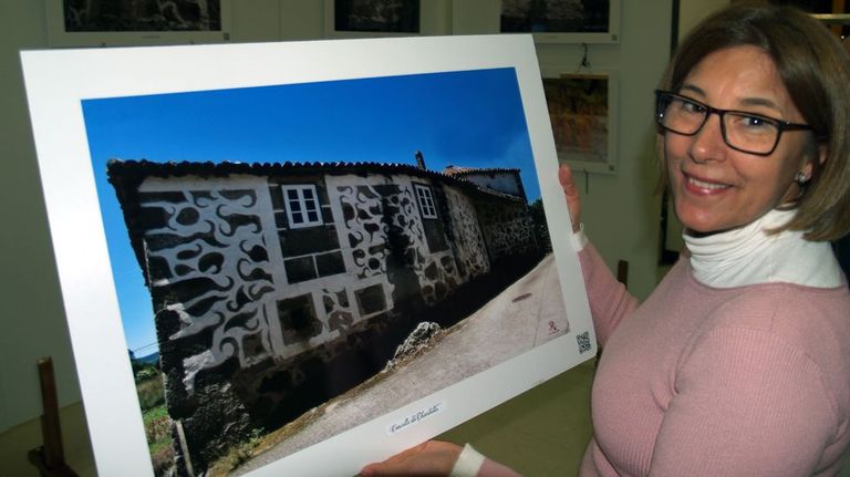 Mar López con una fotografía de una casa con esgrafiado en la fachada.