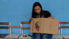 Una mujer con una de las urnas que seran utilizadas en las elecciones presidenciales de Venezuela, el 20 de mayo