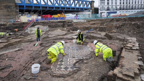 Expertos del Museo Arqueológico de Londres (MOLA) limpian un mosaico romano hallado durante unas obras en la capital británica