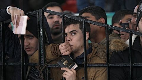 Varios palestinos aguardan para poder entrar en Egipto en el paso fronterizo de Rafah, entre la franja de Gaza y Egipto, en el sur de la franja de Gaza