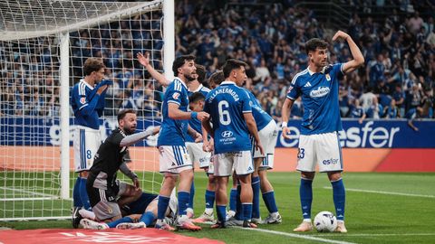 Los jugadores del Real Oviedo en el derbi, mientras Chris Ramos es atendido en el suelo