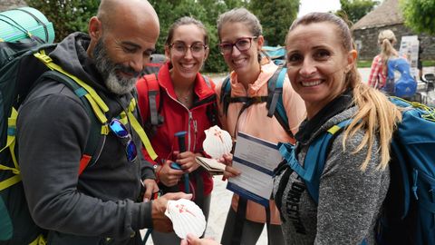 Este grupo de peregrinos ha comprado en O Cebreiro la tradicional concha de vieira, emblema de los que van hacia Santiago
