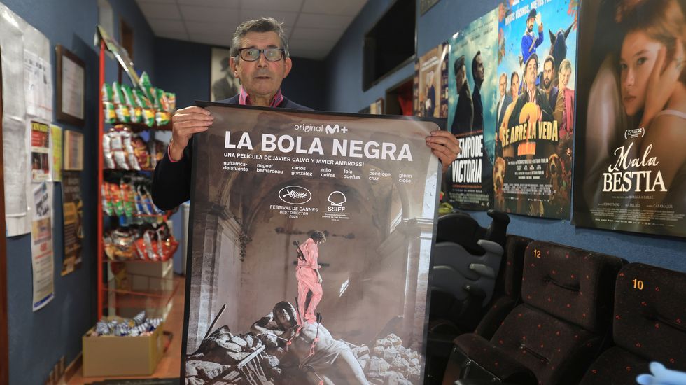 Perfecto Carballo, conocido como Cuco, mostrando el cartel de &laquo;La bola negra&raquo; en su cine de Seixo, en Mar&iacute;n.