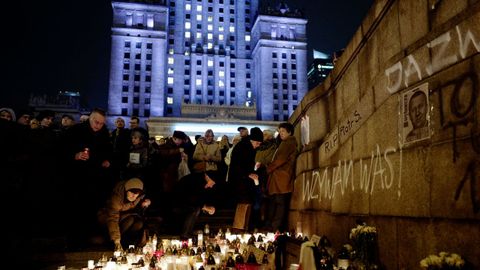 La gente se congrega y enciende velas a la puerta del Palacio de Cultura y Ciencia de Varsovia (Polonia).