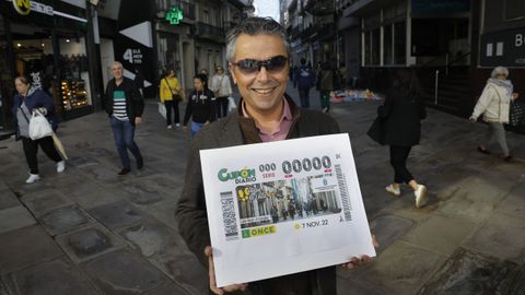 Manuel Martnez Pan, delegado en Galicia de la ONCE, en la calle Real posando con el cupn dedicado a la cntrica va de A Corua.