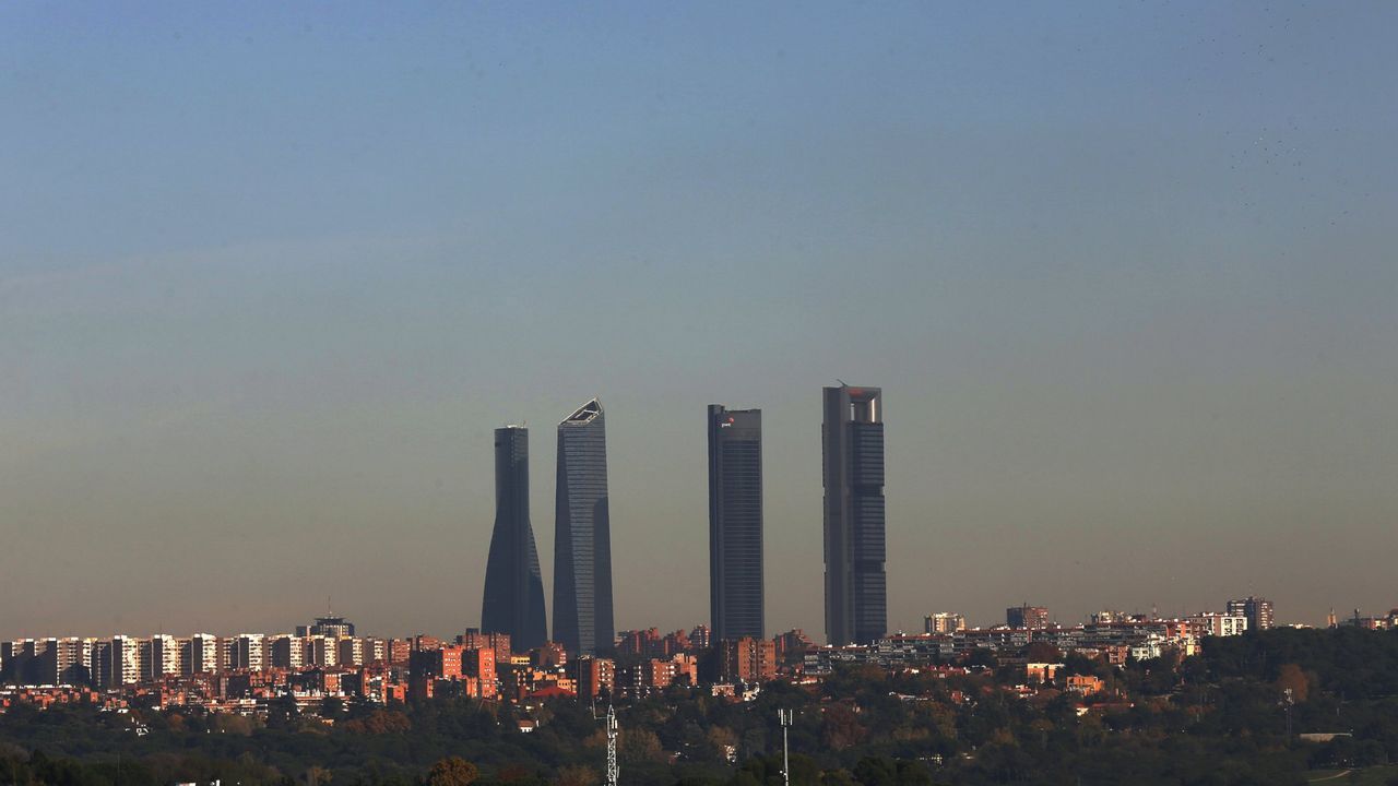 Vista del parque empresarial de las Cuatro Torres, en el Paseo de la Castellana, con la 'boina' de contaminaci�n sobre Madrid