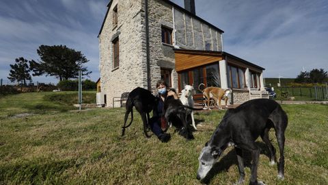 Pascale Claude Monique Huguette con varios de sus 13 galgos ante la casa de O Viso, en Ourol, que ha rehabilitado para vivir ella
