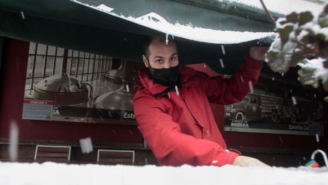 El propietario de un bar de Bóveda cierra el toldo para evitar que el peso de la nieve lo rompa