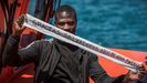 Un inmigrante rescatado en el estrecho de Gibraltar muestra un mensaje de agradecimiento mientras aguarda a ser desembarcado en el puerto de Algeciras