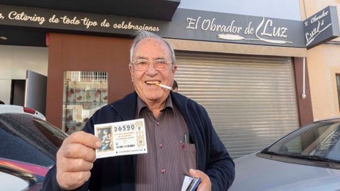  El agraciado con el gordo de la lotera de Navidad Santiago Palazn muestra el dcimo premiado junto al obrador donde lo compr en Las Torres de Cotillas, en Murcia
