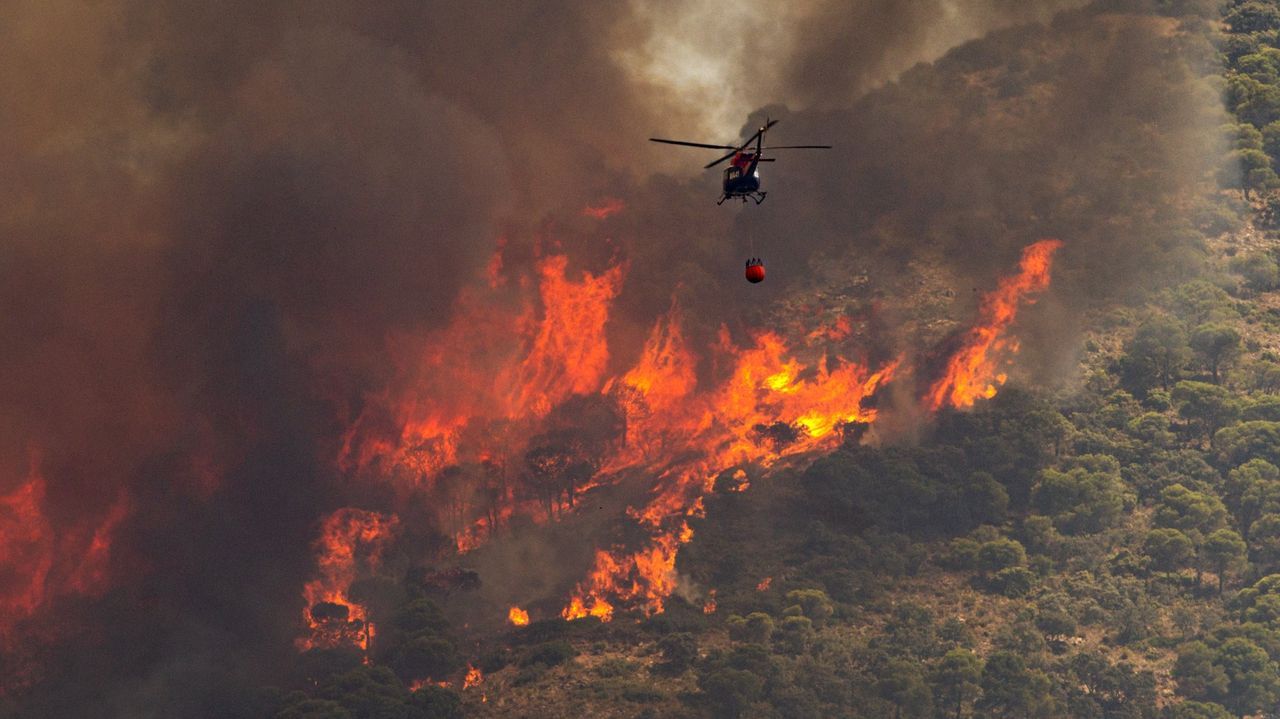Un helicóptero trabaja en las labores de extinción en el incendio de Mijas (Málaga)