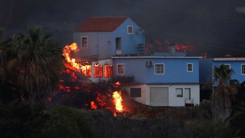 La lava del volcán Cumbre Vieja incendia una casa en la isla canaria de La Palma, vista desde Tajuya.