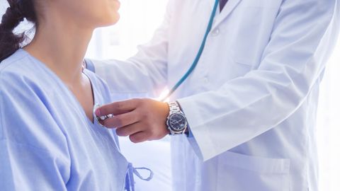 Un médico examina el corazón de una paciente