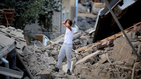 Un hombre se lamenta ante los cascotes de un edificio de Amatrice destrozado por el terremoto que sacudi este mircoles el centro de Italia