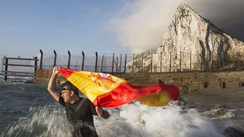 El dirigente de Vox Ortega Smith se zambulle frente al Peñón de Gibraltar ondeando una bandera de España