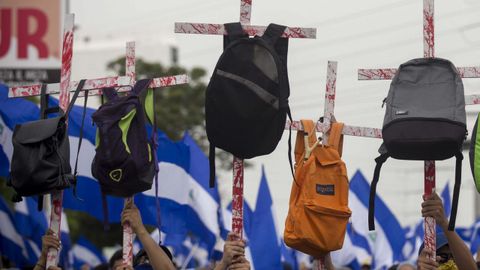 Varios jvenes con unas cruces con mochilas en honor a los estudiantes que murieron en las pasadas manifestaciones participan en una multitudinaria marcha en apoyo a los estudiantes nicaragenses y en rechazo al presidente Daniel Orteg
