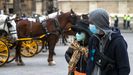 Dos turistas pasean por el casco antiguo de Sevilla con mascarillas