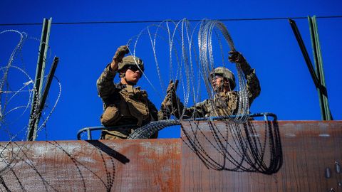 Militares estadounidenses instalan alambradas de puas, vistos desde la colonia Libertad, en Tijuana (México).