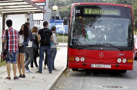 Estudiantes universitarios en una de las paradas del bus que viaja a los campus.