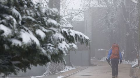 Un hombre camina bajo la nieve en Pedrafita el pasado domingo