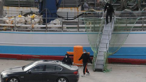 Juan Enrique Padín y su sobrino, Eduardo Rial, accediendo al coche tras desembarcar del Playa de Menduíña al llegar a Terranova el 19 de febrero. Muy por detrás, Samuel Koufie, poco después de recibir la llamada del armador para, presuntamente, presionarlo y que declare lo mismo que los otros dos supervivientes.