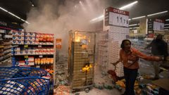 Una empleada intenta apagar el fuego provocado por los manifestantes